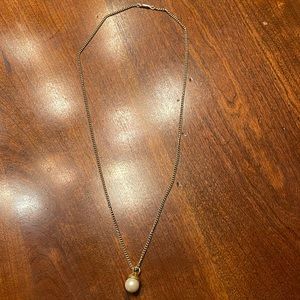 Long gold toned necklace with pearl drop. Simple elegance.